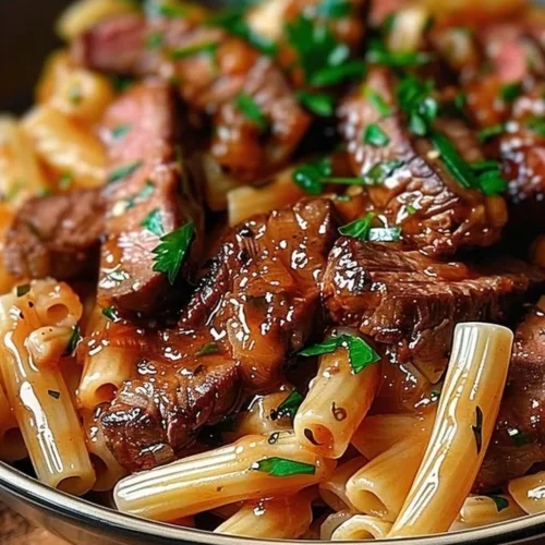 Spicy honey BBQ steak pasta dish served in a skillet