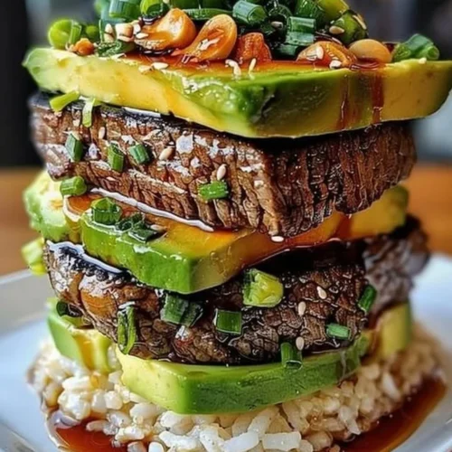 Teriyaki beef with avocado rice stacked in a vibrant dish