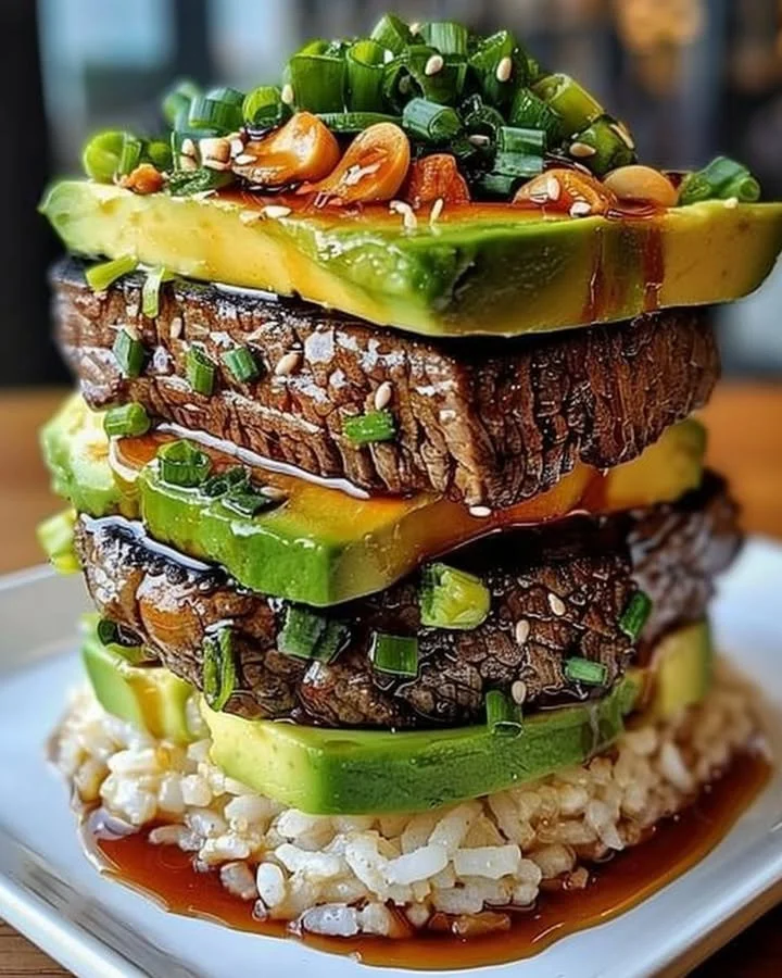 Teriyaki beef with avocado rice stacked in a vibrant dish
