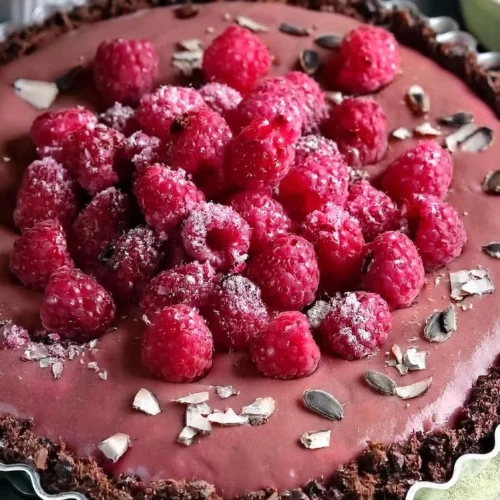 Delicious Vegan Raspberry Chocolate Tart topped with fresh raspberries.