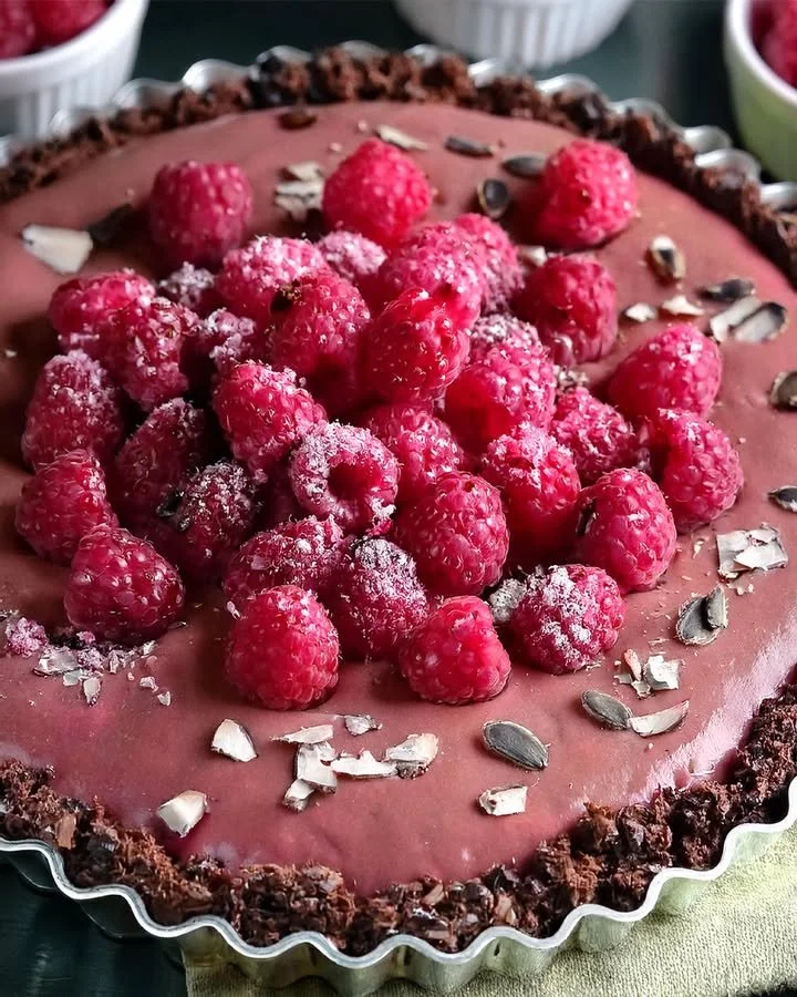 Delicious Vegan Raspberry Chocolate Tart topped with fresh raspberries.