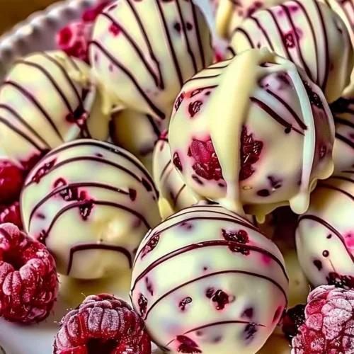 White chocolate raspberry cheesecake balls on a dessert plate